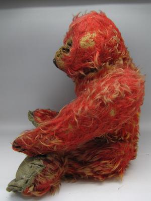 Very threadbare red teddy bear