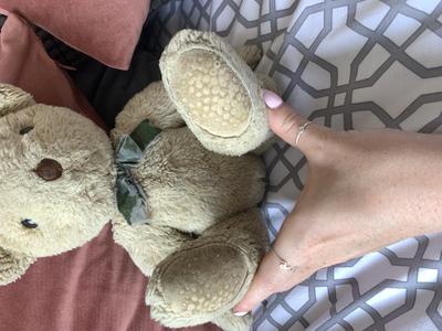 foot of teddy bear with green bow