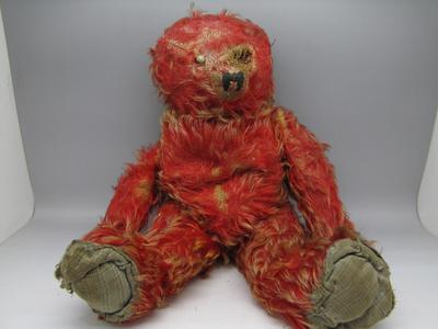 Very threadbare red teddy bear